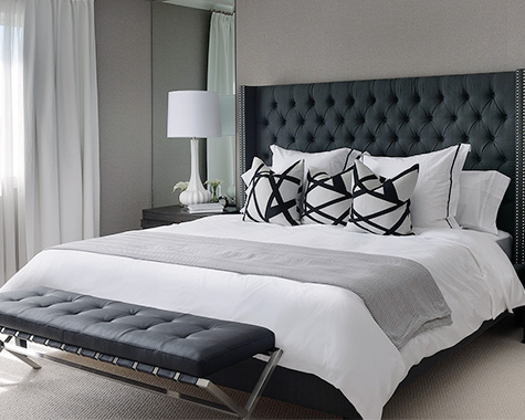 black tufted headboard in a black and white bedroom