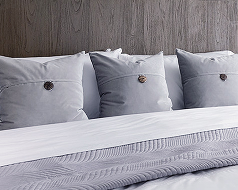 3 grey decorative pillows on a bed
