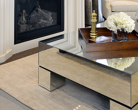 mirrored coffee table with a wood serving tray on top