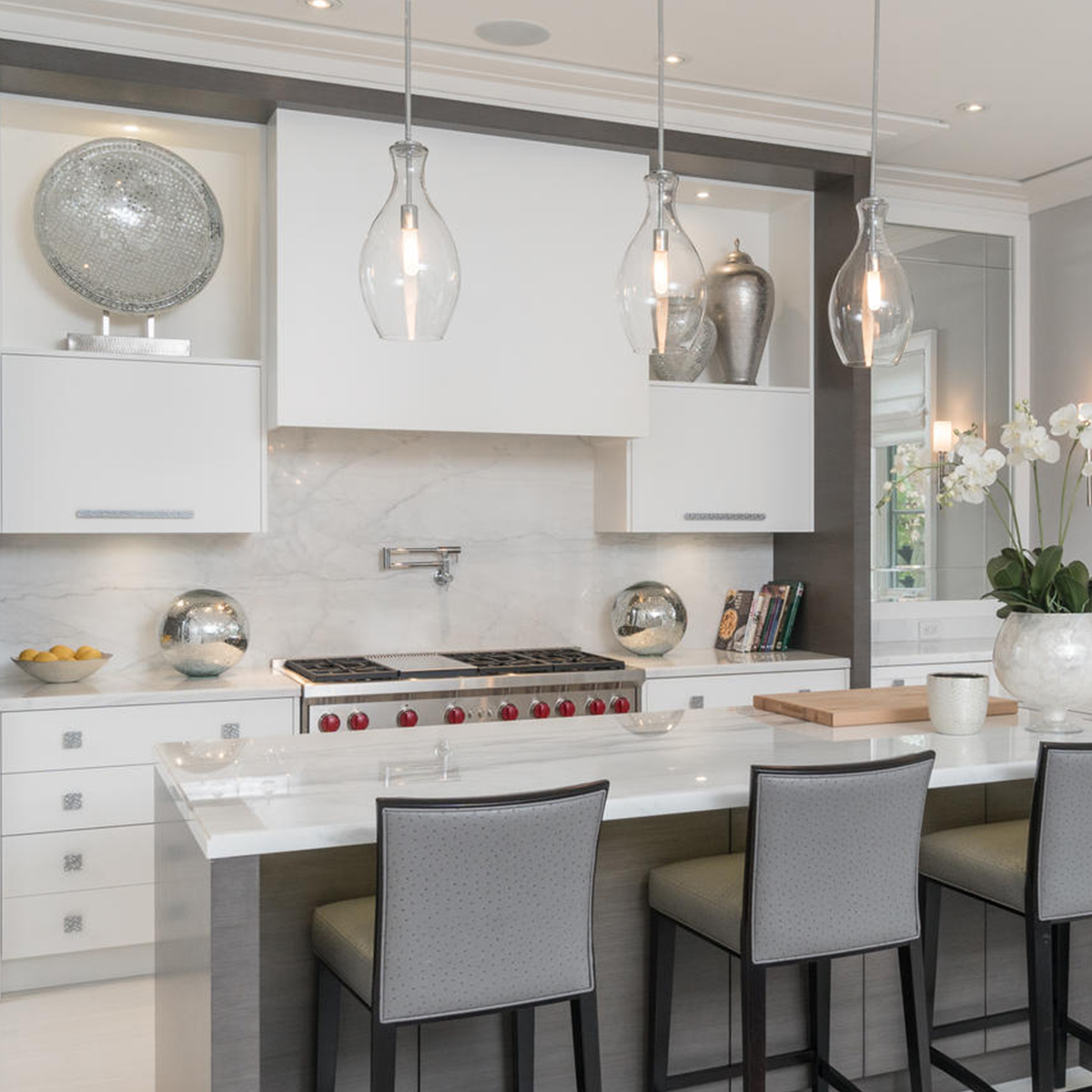 clean modern white kitchen with glass lighting over island